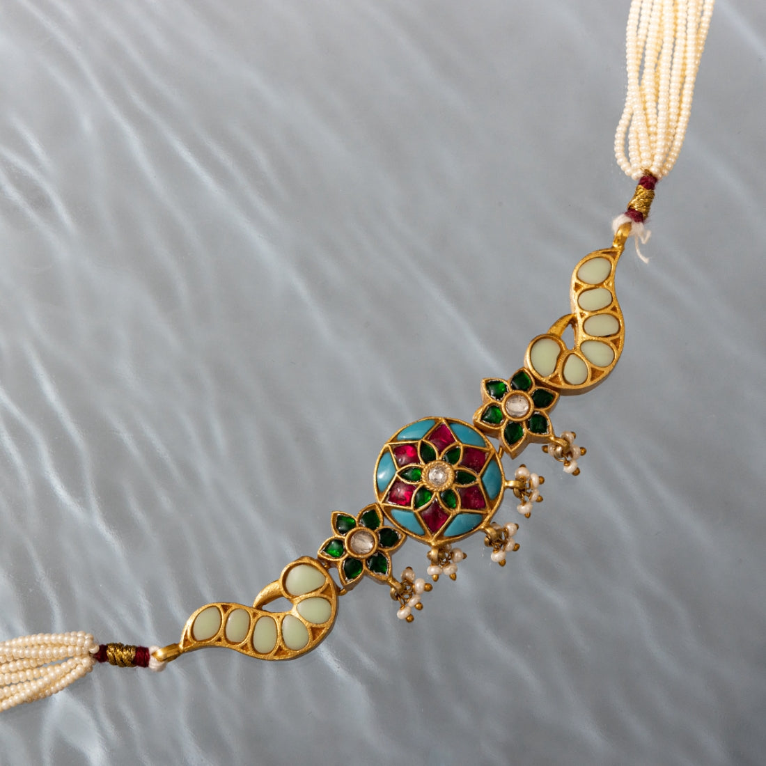 Gold-plated choker featuring colorful floral and peacock motifs with adjustable sizing and pearl strands on both sides.