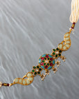 Gold-plated choker featuring colorful floral and peacock motifs with adjustable sizing and pearl strands on both sides.