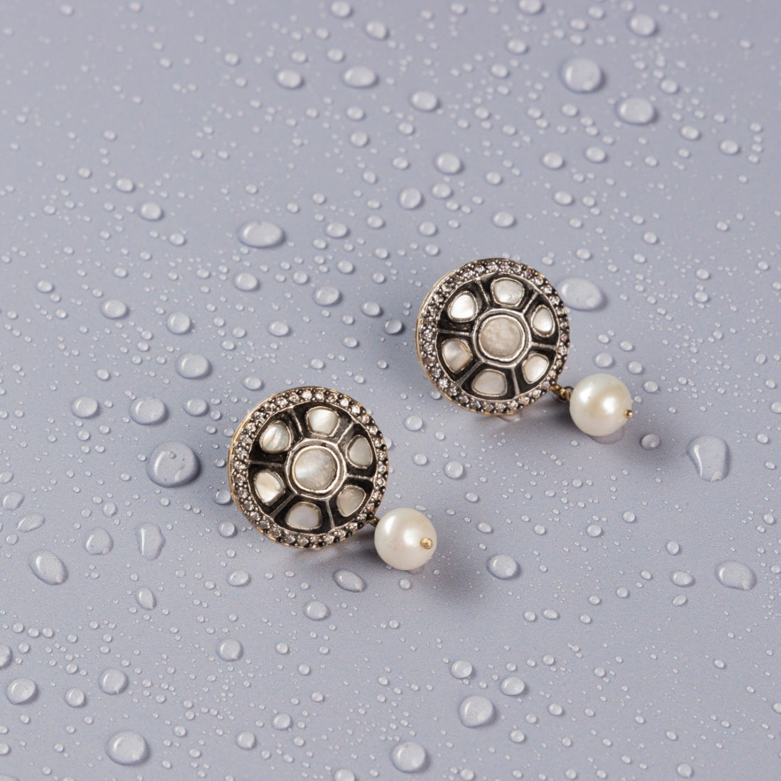 Sterling silver stud earrings featuring CZ stones surrounding polkis, with a vintage Victorian finish and delicate pearl drops.