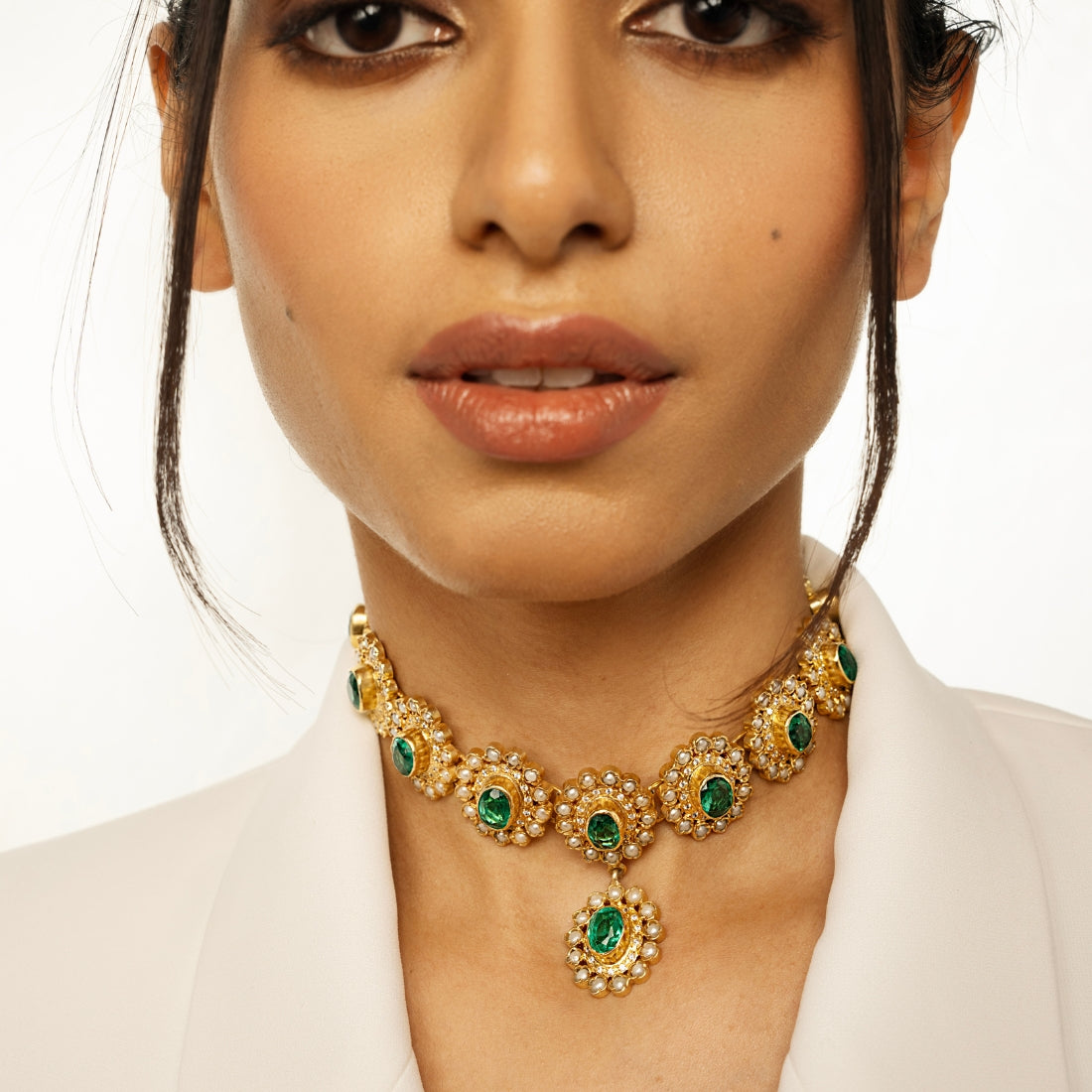 Gold-plated choker necklace featuring round emerald green stones arranged in a sunflower pattern.