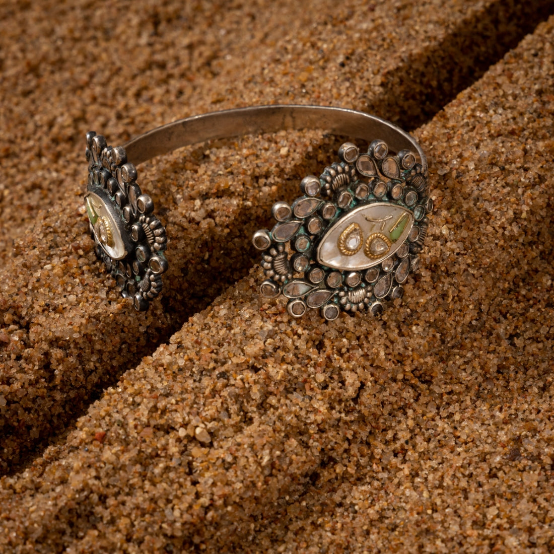 Men's silver cuff bracelet with an oxidized finish featuring marquise-shaped mother of pearl stones, rose-cut CZ stones, and tribal motifs.