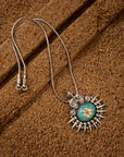 Turquoise pendant crafted from sterling silver featuring a genuine turquoise gemstone on a grainy background.