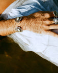 Men's silver cuff bracelet with an oxidized finish featuring marquise-shaped mother of pearl stones, rose-cut CZ stones, and tribal motifs.