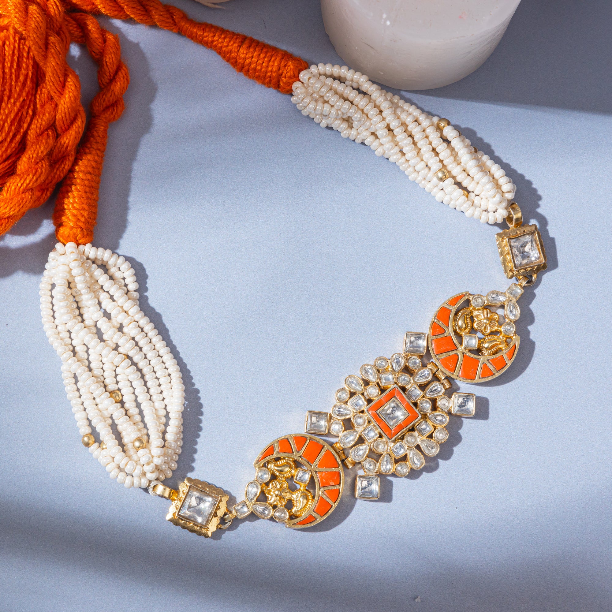 Polki-style choker necklace featuring coral-colored stones in a moon pattern and a centerpiece with coral and square-shaped polki stones.