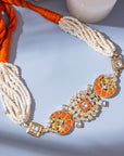 Polki-style choker necklace featuring coral-colored stones in a moon pattern and a centerpiece with coral and square-shaped polki stones.