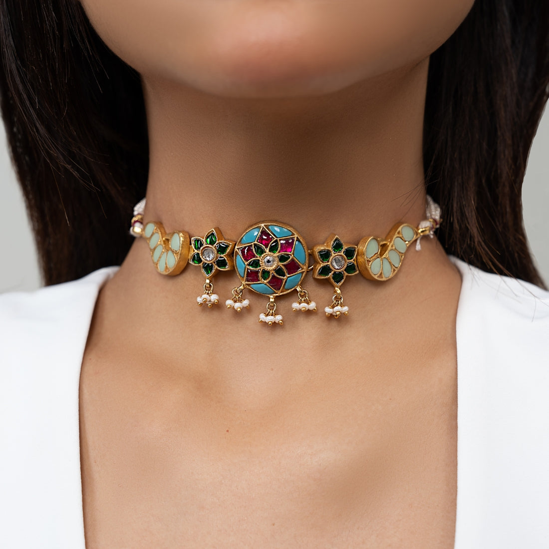 Gold-plated choker featuring colorful floral and peacock motifs with adjustable sizing and pearl strands on both sides.