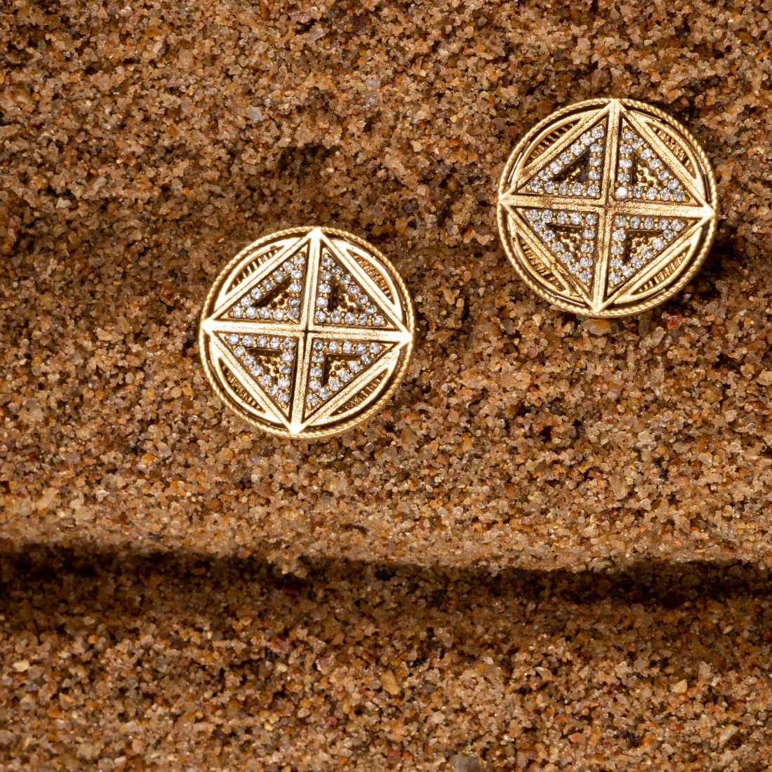 Silver stud earrings featuring intricate geometric patterns with an antique gold finish.