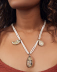 Jadau long necklace featuring a grey center stone with polki detailing, flanked by claw and pear-shaped charms. Delicate pearl strands complete the design.