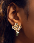 Silver stud earring featuring a floral motif with polki detailing, a pastel green bead, and cascading pearls.